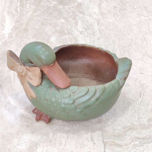 Alt Tag:
Elegant swan-shaped ceramic plant pot for tabletop and shelf decor