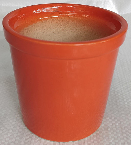 Shiny orange ceramic plant pot"