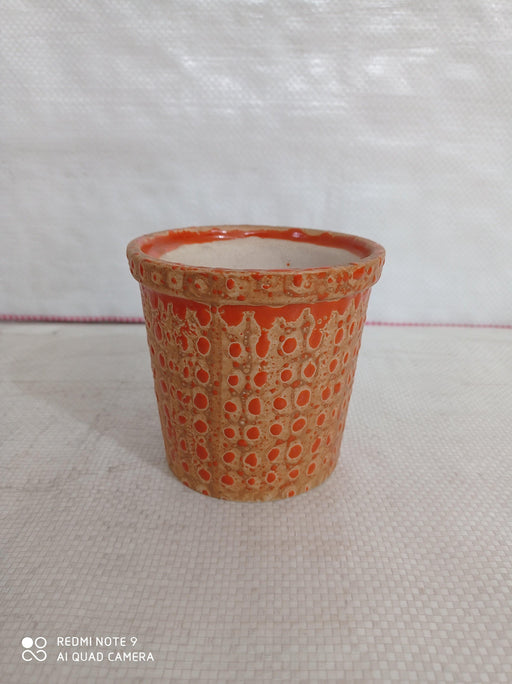 Contemporary round ceramic pot in orange with dotted design