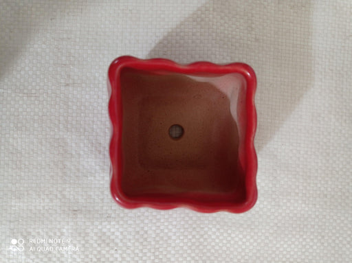 Elegant small red ceramic pot with a glossy finish