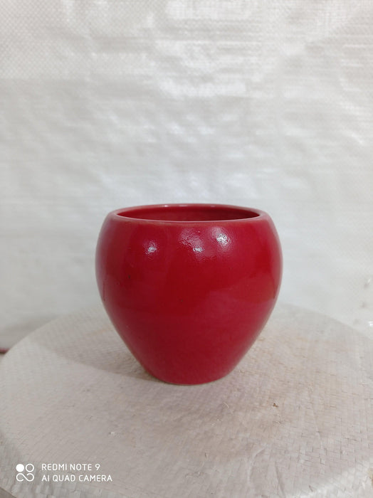 Apple-shaped ceramic plant pot in vibrant red