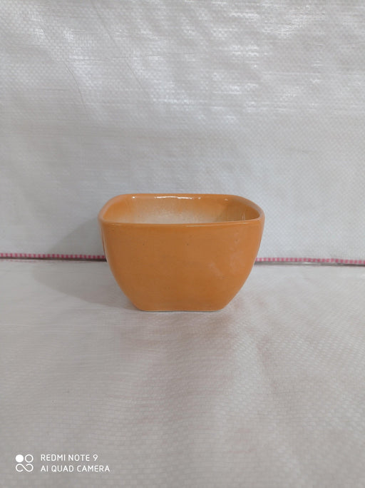 Square ceramic plant pot in light orange color