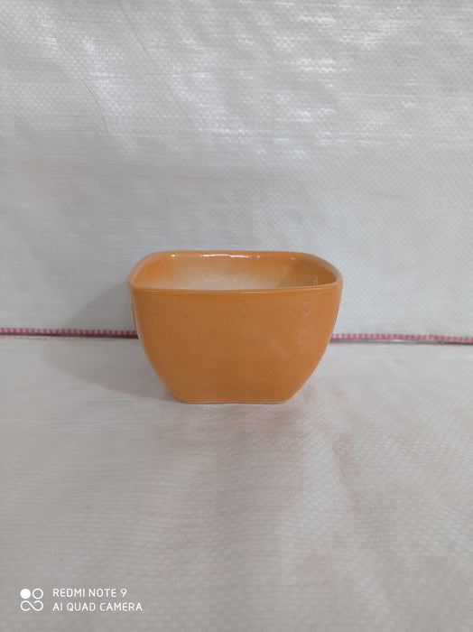 Square ceramic plant pot in light orange color